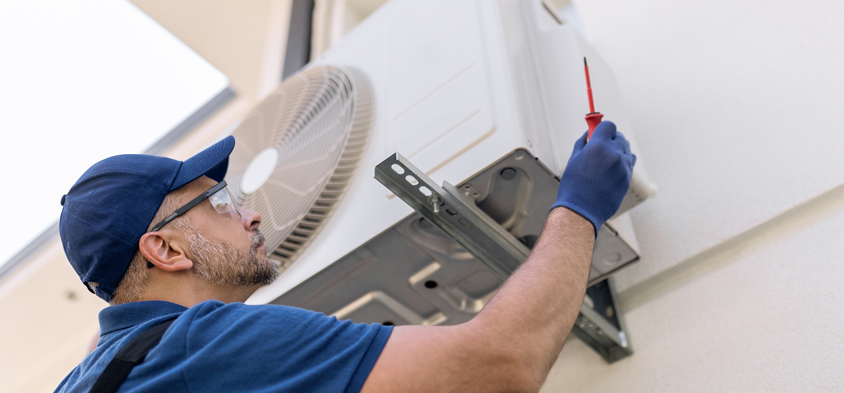 HVAC technician repairing AC unit