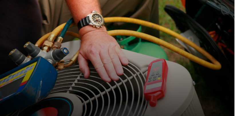 Hand on air conditioning unit with tools