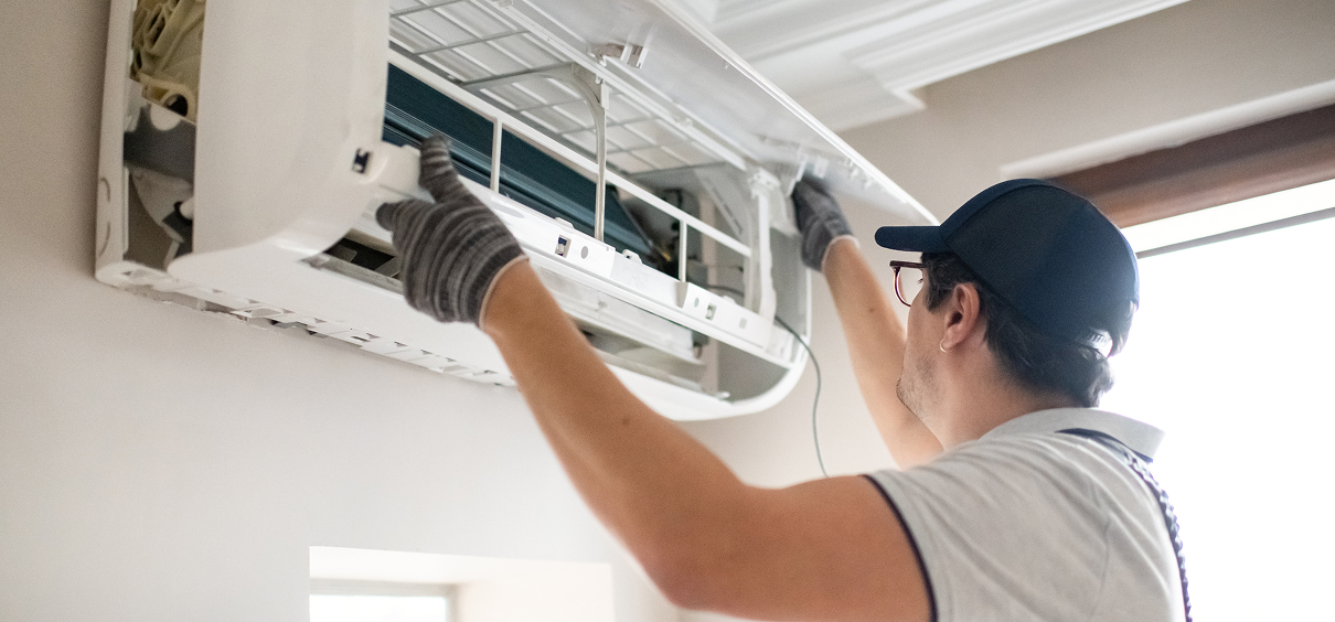 Worker maintaining indoor AC system